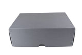 A plain gray cardboard box photographed from above on a white fabric background.