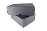 A plain gray cardboard shoe box with its lid partially open, set on a white draped fabric background.